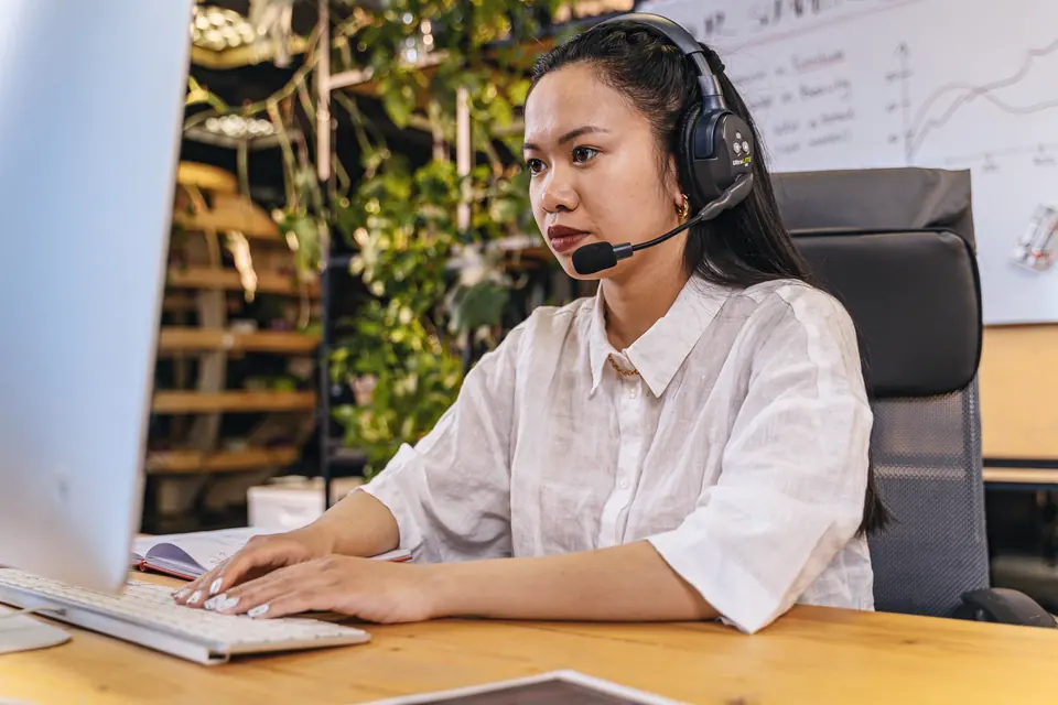 Dispatcher wearing a headset working at a computer